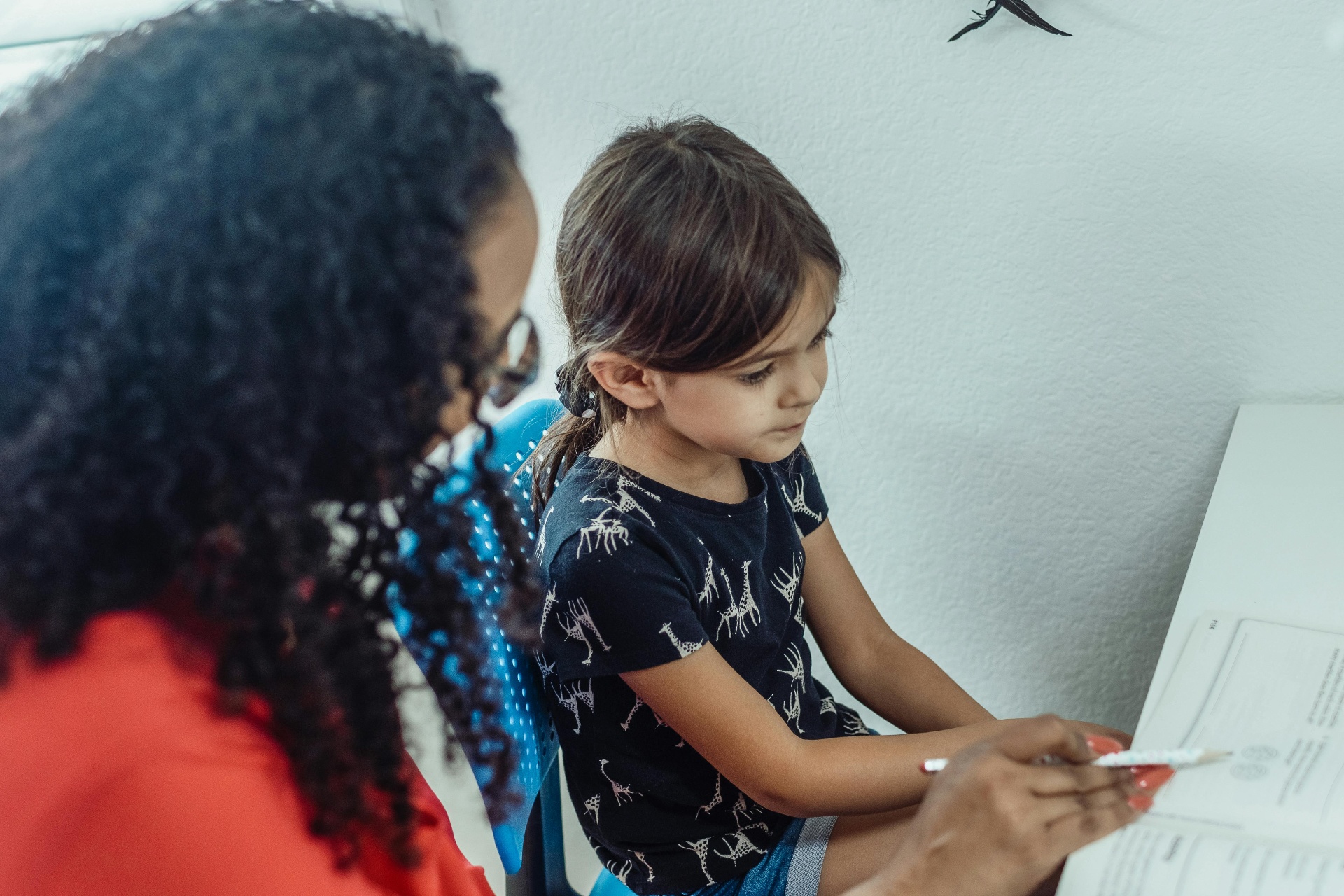 Tutor helping child with worksheet